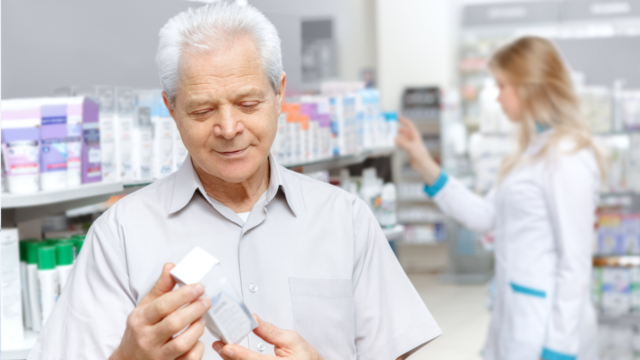 middle aged man comparing products in pharmacy